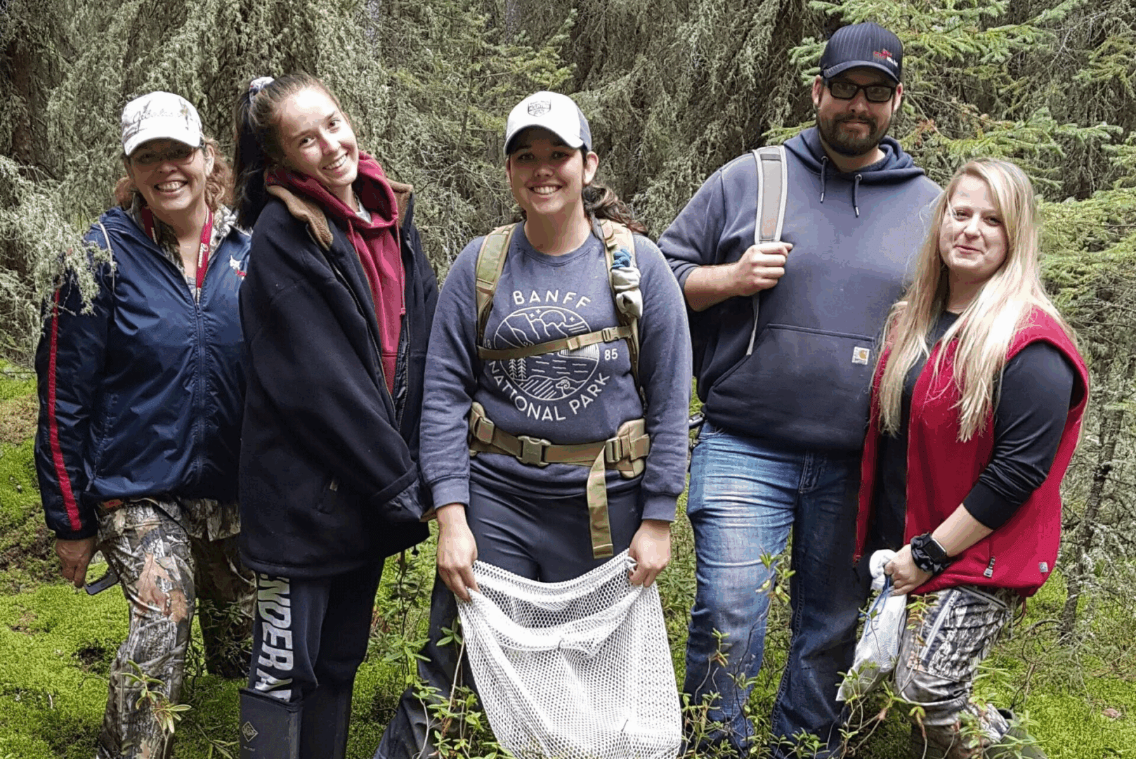 Group of people hiking in forest.