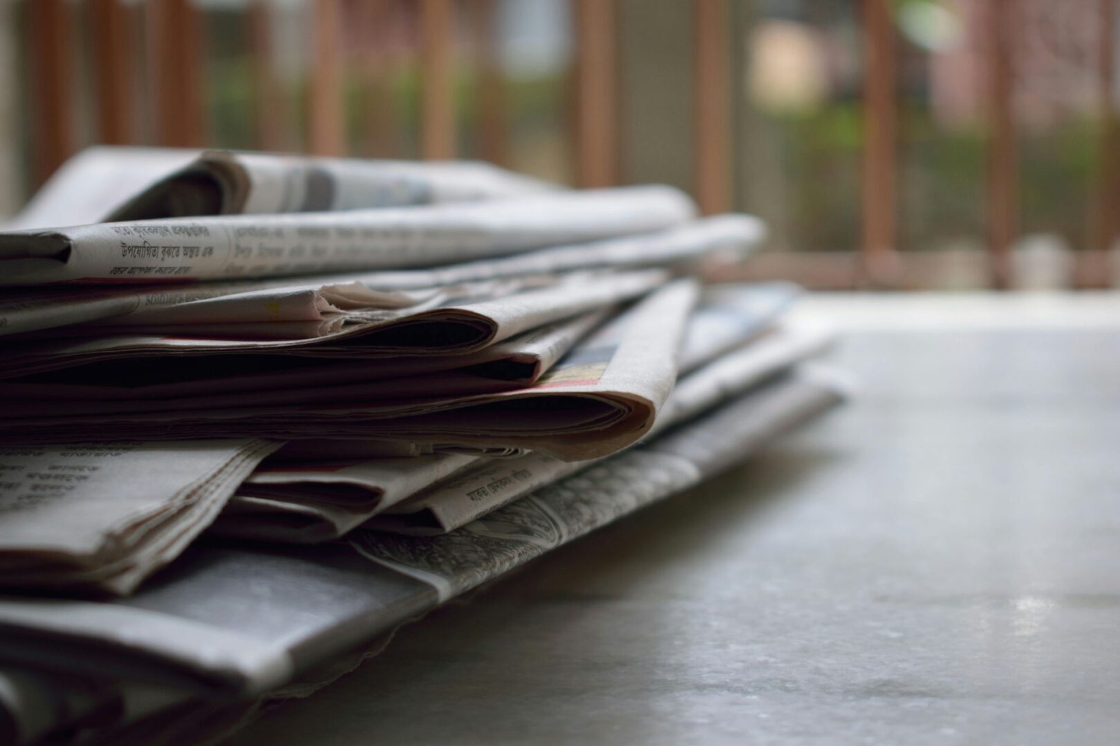 Stack of newspapers on a table.